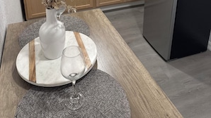 A modern kitchen with wooden cabinets, a stainless steel refrigerator, a microwave, and a vase with dried flowers on the counter. - Bienes House private property in Brandon (Brandon)