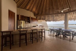 Eine Küche mit Bar, einem Essbereich und Blick aufs Meer.
