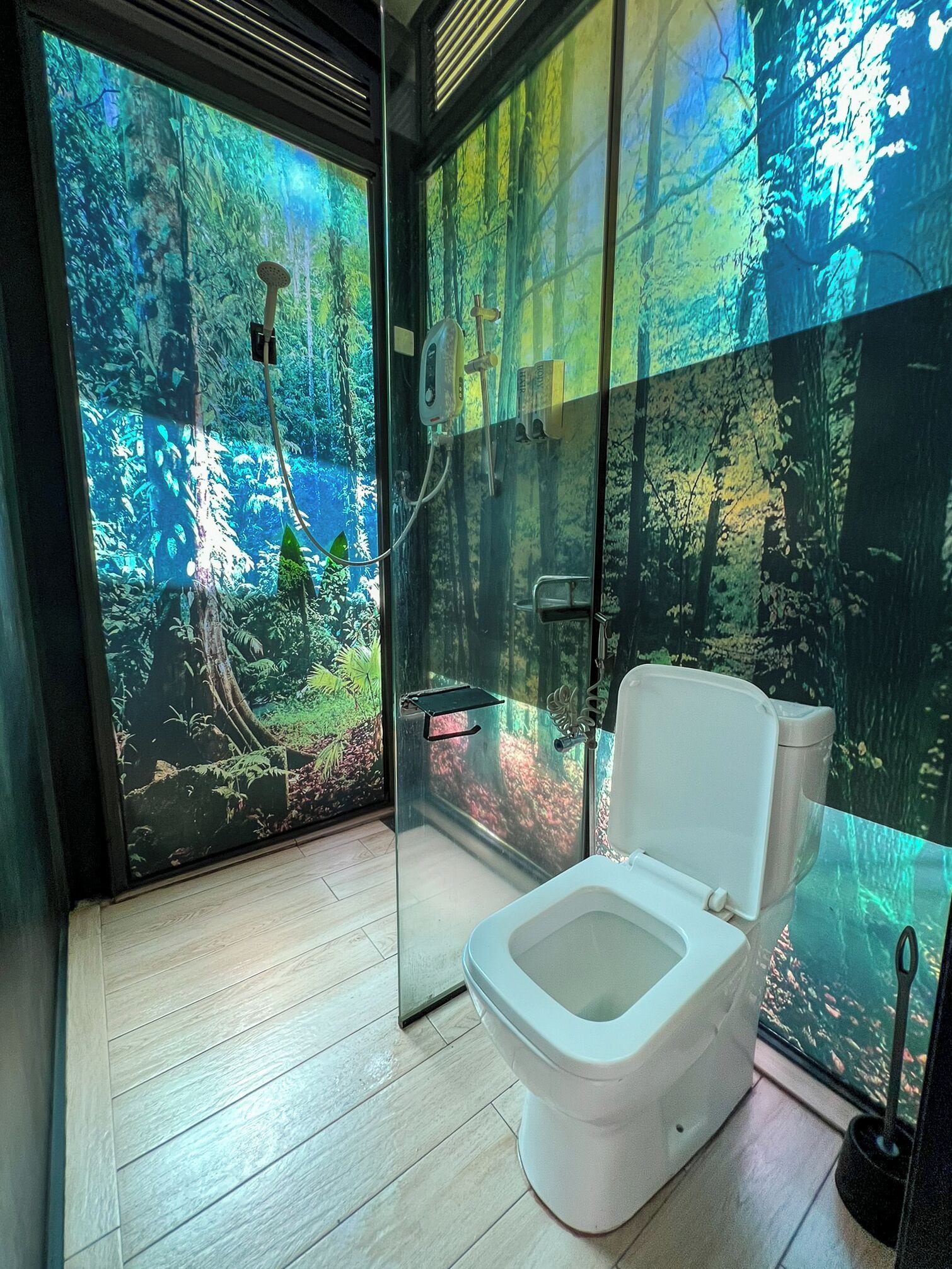 A modern bathroom with a glass enclosure, a toilet, and a shower.