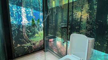 A modern bathroom with a glass enclosure, a toilet, and a shower.