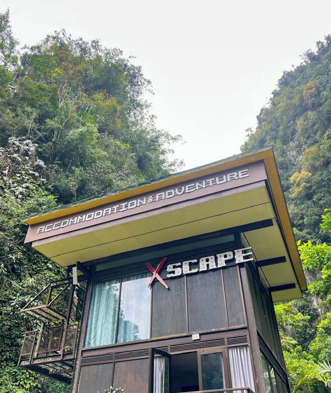 A building with a sign reading "ACCOMMODATION & ADVENTURE" and "X SCAPE".