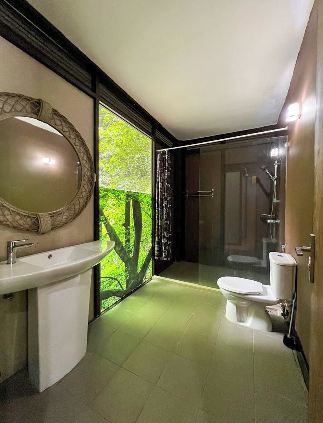 Ein modernes Badezimmer mit großem Spiegel, Waschbecken, Toilette und Duschbereich.