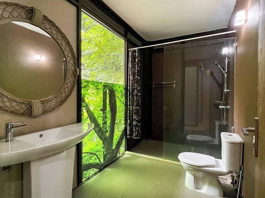 Ein modernes Badezimmer mit großem Spiegel, Waschbecken, Toilette und Duschbereich.