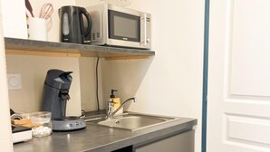 A compact kitchenette with a microwave, kettle, and coffee maker on the countertop. - L'Angevin-4 pers-espace repas-Centre ville/Gare station (Le Mans)