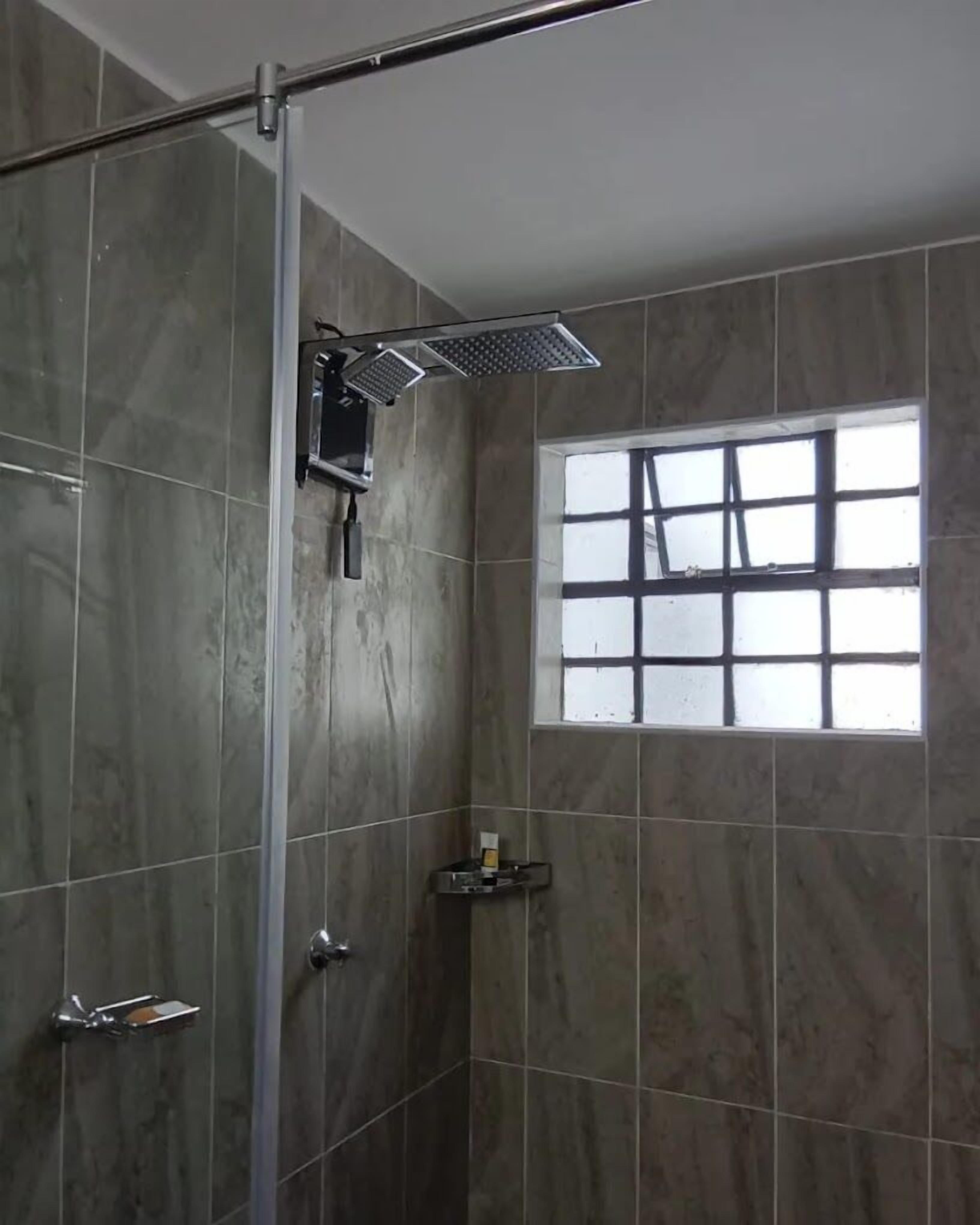 Deluxe tweepersoonskamer, uitzicht op tuin | Badkamer | Een douche, gratis toiletartikelen, pantoffels, handdoeken