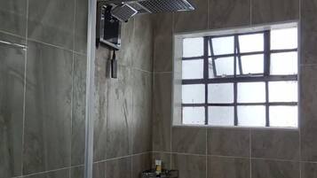 Deluxe tweepersoonskamer, uitzicht op tuin | Badkamer | Een douche, gratis toiletartikelen, pantoffels, handdoeken