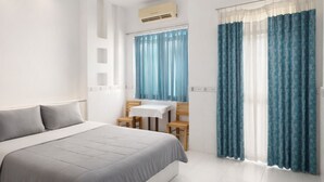 A modern bedroom with a bed, a desk, and two chairs. - CKC 24H Hotel Near Can Tho City Center (Can Tho)