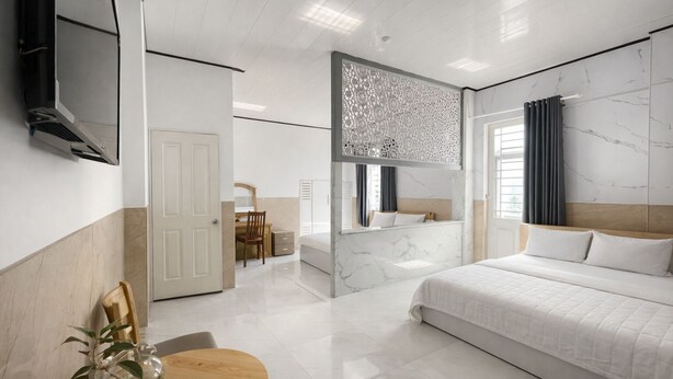 A modern hotel room with a large bed, a desk, and a seating area. - CKC 24H Hotel Near Can Tho City Center (Can Tho)
