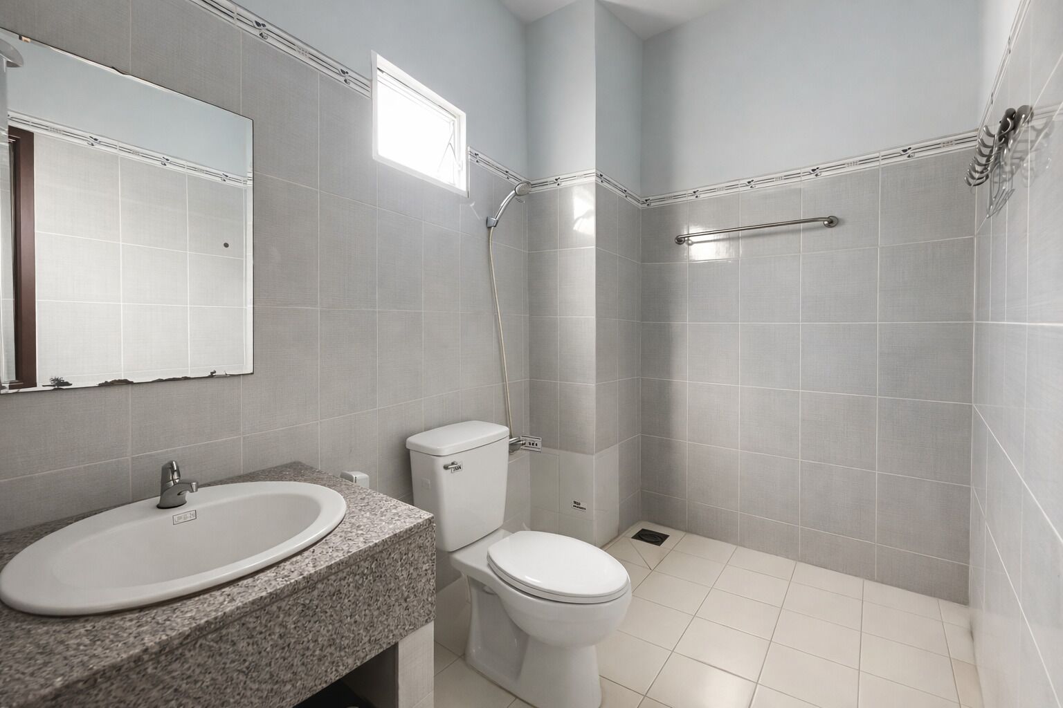 Un baño moderno con lavamanos, inodoro y ducha.