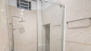 A modern bathroom with a glass shower enclosure, a marble-tiled floor, and a white sink. - CKC 24H Hotel Near Can Tho City Center (Can Tho)