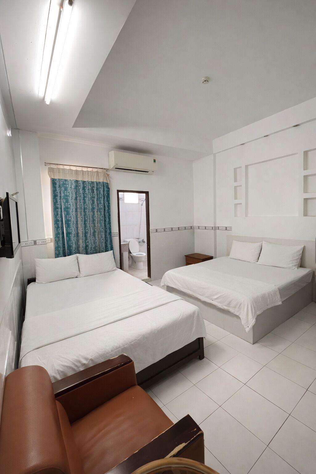 Une chambre d’hôtel avec deux lits, une salle de bain et un coin salon.