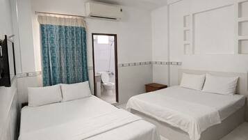 Une chambre d’hôtel avec deux lits, une salle de bain et un coin salon.