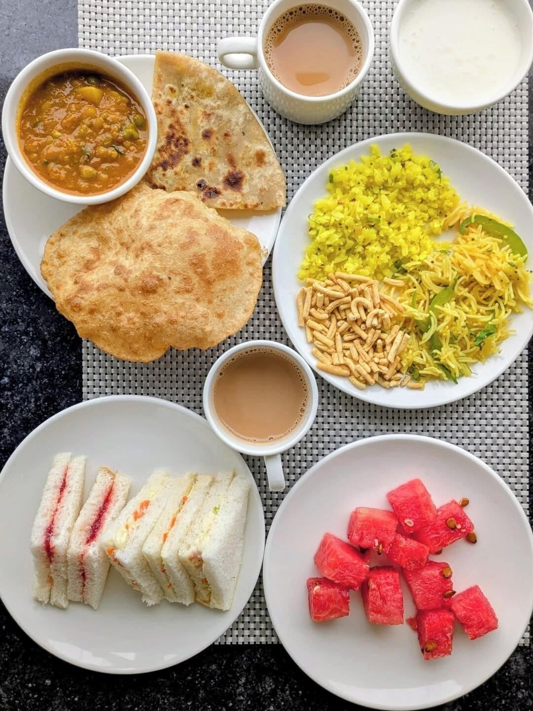 A meal with various dishes including flatbread, rice, and sandwiches.