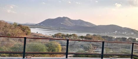 An infinity pool with a view of a mountain range and a body of water.