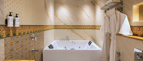 A modern bathroom with a large bathtub, a shower, and a vanity with a mirror.