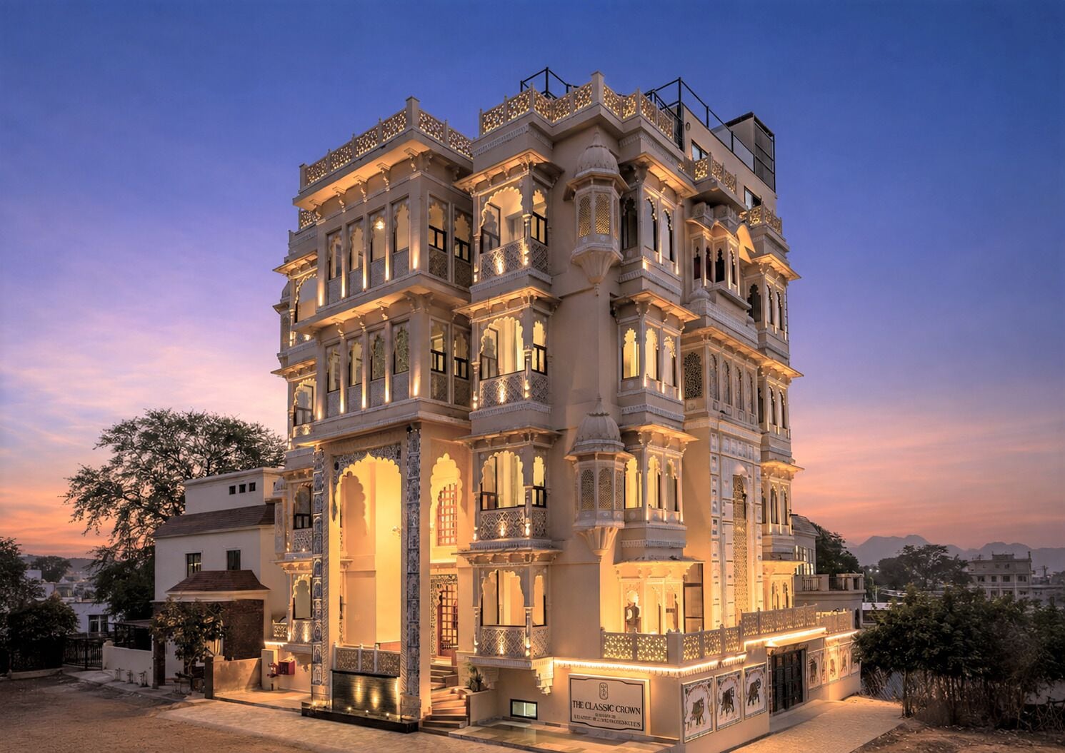 Um edifício de vários andares com detalhes arquitetônicos elaborados, incluindo arcos e colunas, e uma placa indicando que é 'The Classic Crown'.