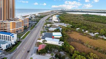 A coastal road with buildings, a bridge, and a water body.