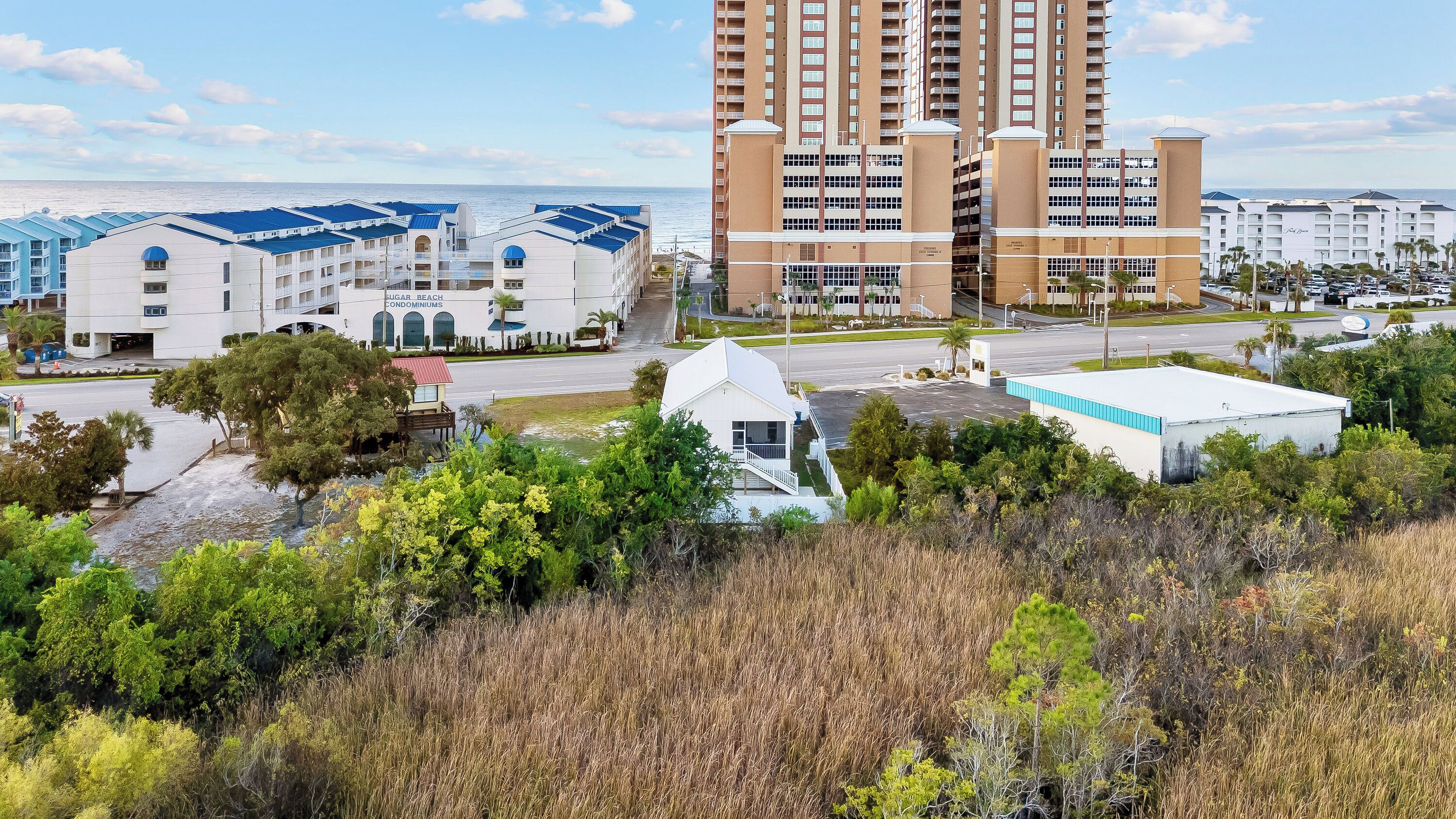 Un complejo hotelero frente al mar, con varias edificaciones, incluyendo un hotel alto y varias estructuras más pequeñas.
