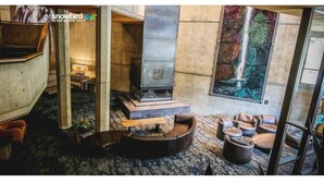 A modern interior with a fireplace, seating areas, and a view of a waterfall. - Ski-in-ski-out Snowbird, X-large studio, Alta, LCC Hot Tub, Heated Pool (Snowbird)