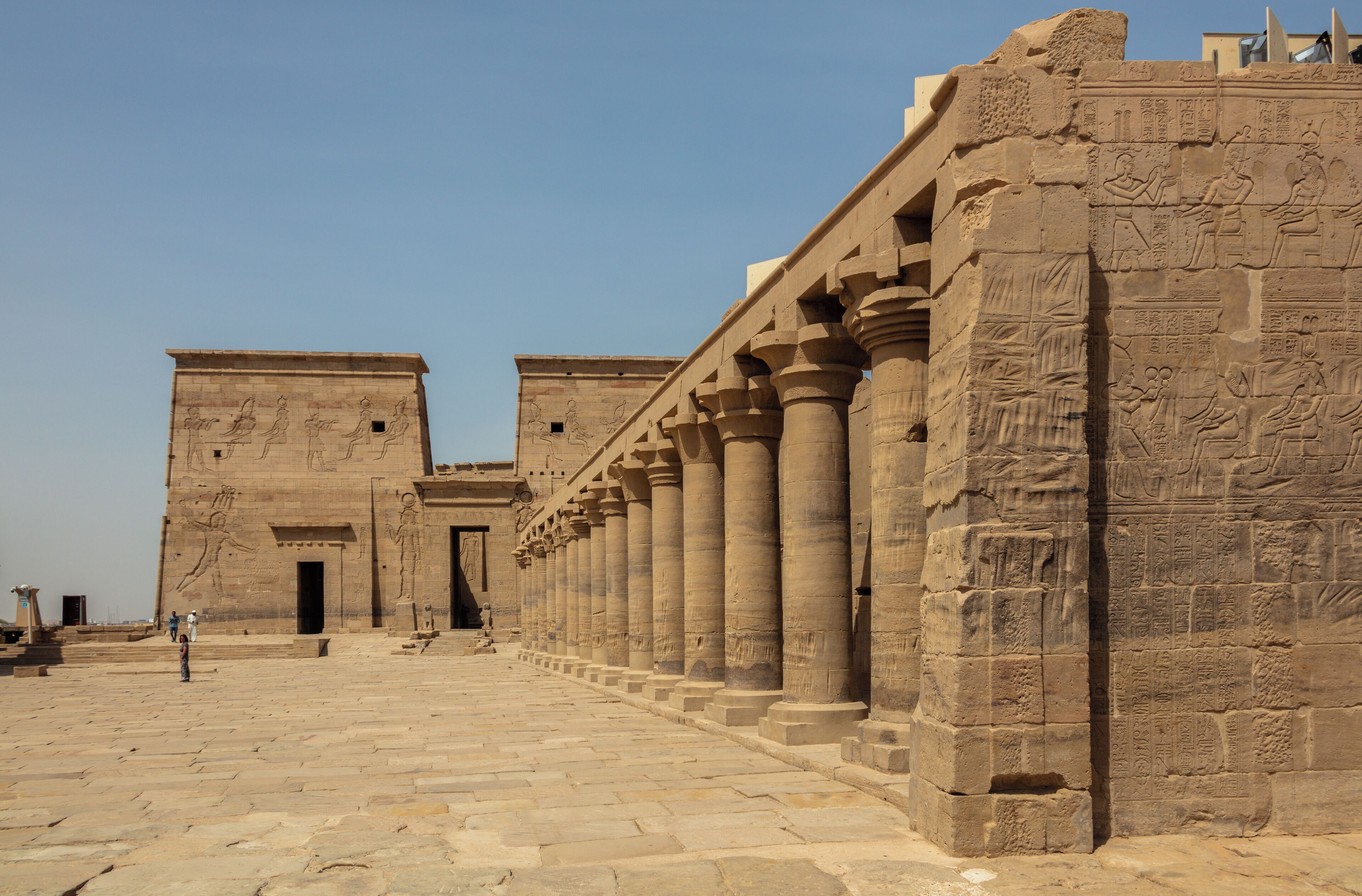 A grand entrance with large columns and hieroglyphic carvings, leading to a temple-like structure.