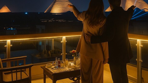 A couple on a balcony overlooking illuminated pyramids at night. - Nefri Pyramids Hotel (Giza)
