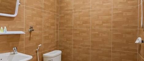 A bathroom with a toilet, sink, and shower.