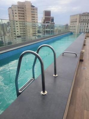 A rooftop swimming pool with metal railings and a cityscape view in the background. - Charming apartment in enchanting São Paulo in a central place and near to subway (São Paulo)