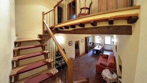 Ein geräumiger Wohnbereich mit einer Holztreppe, die in einen oberen Bereich führt.