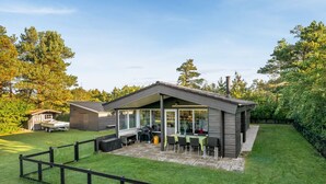 A modern house with a patio, a barbecue area, and a fenced yard. - "Sjarlotte" - 400m to the fjord by Interhome (Skjern)