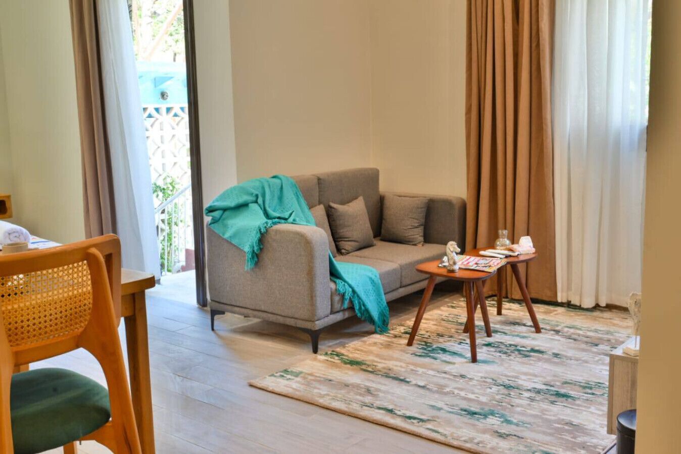 Ein gemütliches Wohnzimmer mit einer Couch, einem kleinen Tisch und einem Sessel.