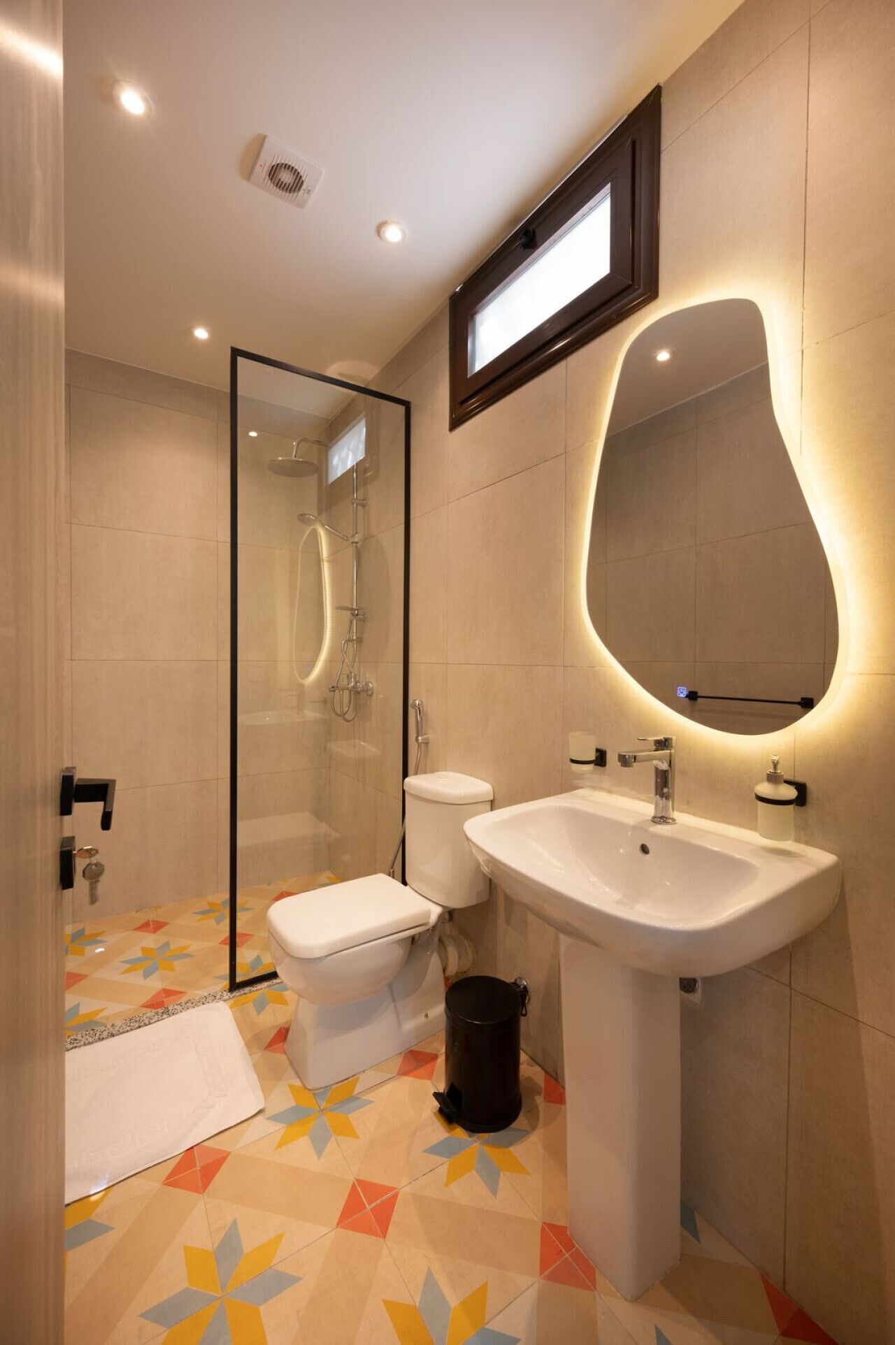 Ein modernes Badezimmer mit einer Duschkabine, einem weißen Waschbecken und einer Toilette.
