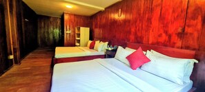A hotel room with two beds, wooden walls, a wardrobe, and a nightstand with toiletries. - Sun&Roots Lodge Restaurant and Bar (Kampot)