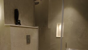 A modern bathroom with a glass-enclosed shower, a white toilet, and a built-in sink. - Hotel Maharaja Crest (Katra)