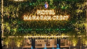 The exterior of Hotel Maharaaja Crest with a prominent sign, a decorative wall, and a fountain. - Hotel Maharaja Crest (Katra)