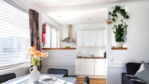 Een moderne keuken met witte kastjes, een roestvrijstalen afzuigkap en een hangplant.