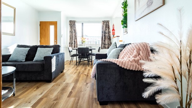 Een moderne woonkamer met twee banken, een eettafel en stoelen.