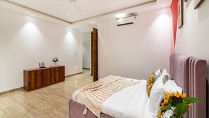 Un dormitorio con cama, un armario de madera, un equipo de aire acondicionado y un ventilador de techo.