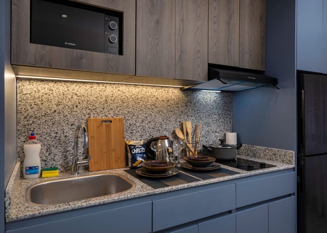 A modern kitchen with granite countertops, stainless steel appliances, and wooden cabinets.