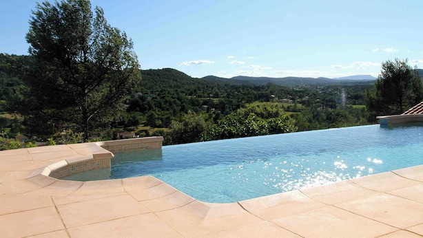 A swimming pool with a view of a hilly landscape.