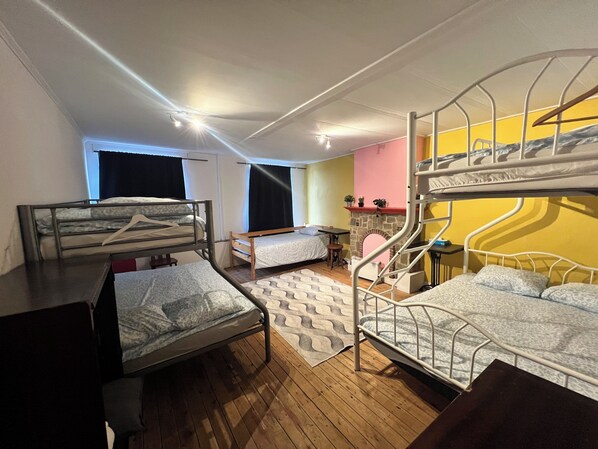 Une chambre de dortoir avec des lits superposés, une petite table, une chaise et une fenêtre.
