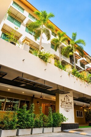 A hotel with a sign reading 'STAR HOTEL,' balconies with plants, and a modern architectural style. - Relax Corner Jomtien – Spacious Studio with Balcony (Muang Pattaya)