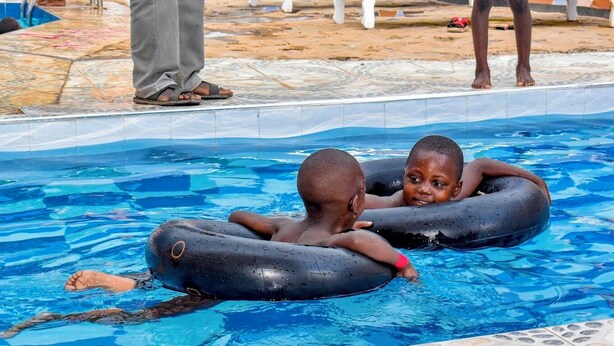Two children floating in a pool with inflatable rings. - Pennjoki Resort (Kakamega)