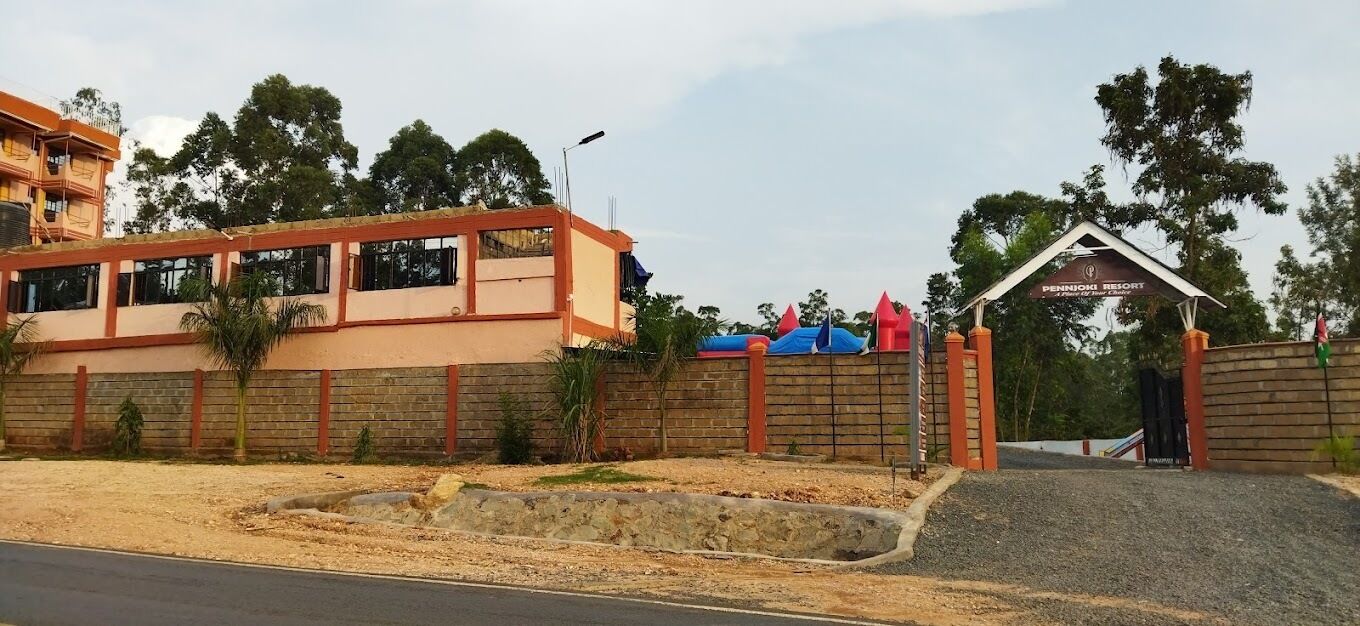 A building with a brick facade, a gated entrance, and a sign for Pennoni Resort.
