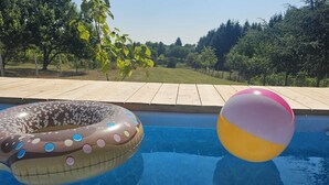 Una piscina con un cerchio gonfiabile a forma di ciambella e un pallone da spiaggia.