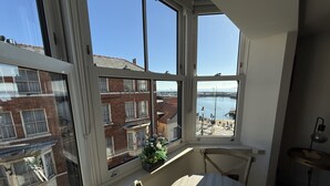 A room with large windows overlooking a marina and a red brick building. - Merchants Quarters - Laguz & Othala - sleeps 8 guests  in 4 bedrooms (Scarborough)