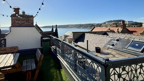 A rooftop terrace with a view of the sea, a brick chimney, and a table with chairs. - Merchants Quarters - Laguz & Othala - sleeps 8 guests  in 4 bedrooms (Scarborough)