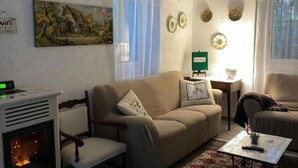 A cozy living room with a fireplace, a sofa, a coffee table, and a painting on the wall. - Crosa Rosella (Bardineto)