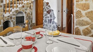 A dining area with a stone wall, wooden staircase, and a rustic fireplace. - Beautiful apartment for 6 people with pool, WIFI, A/C, TV and patio (La Maddalena)