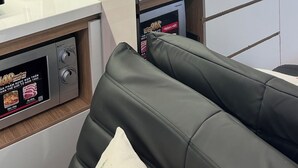 A modern kitchen with a built-in stove, a sink, and a countertop. There is a black leather couch and a plant in the corner. - Unite StayCation Le Van Sy (Ho Chi Minh City)