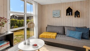 Un salon moderne avec un canapé, une petite table et une bibliothèque.